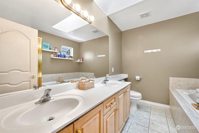 bathroom with tile patterned flooring, a skylight, vanity, a relaxing tiled tub, and toilet