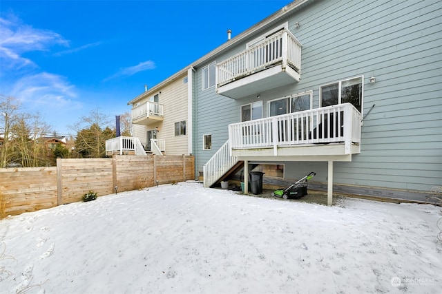 snow covered house featuring a balcony