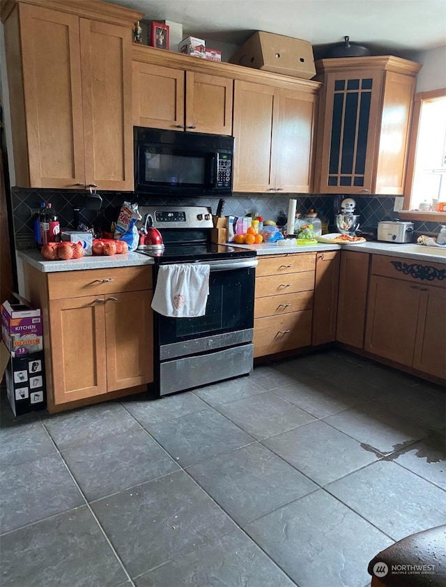 kitchen with stainless steel electric stove and backsplash