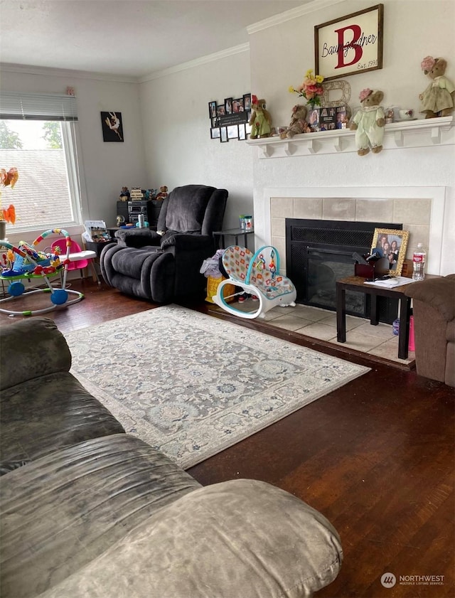 living room with hardwood / wood-style flooring, ornamental molding, and a fireplace