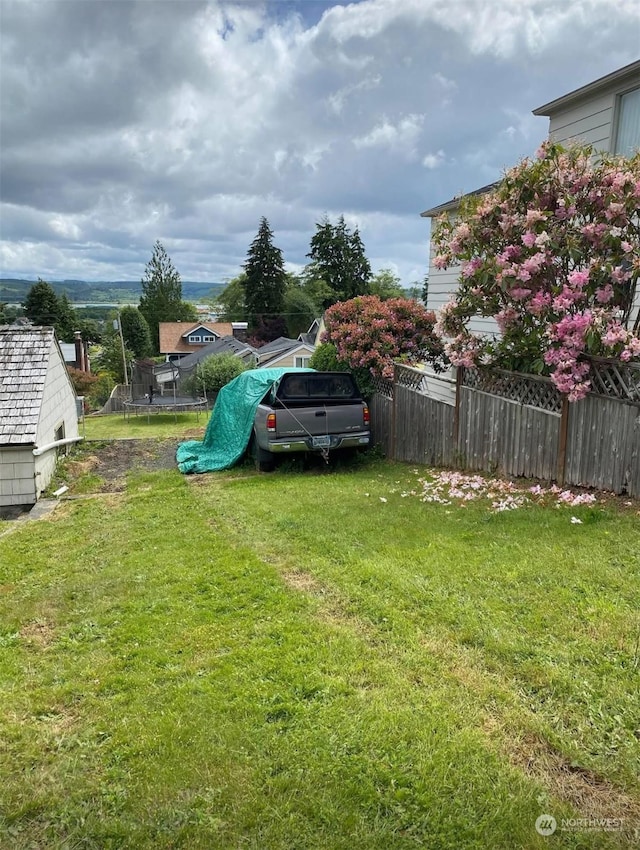 view of yard with a trampoline and a playground