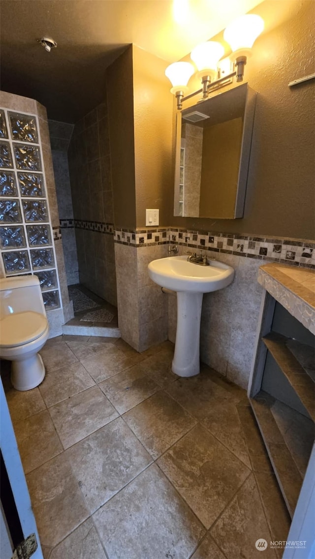 bathroom with tile walls and toilet