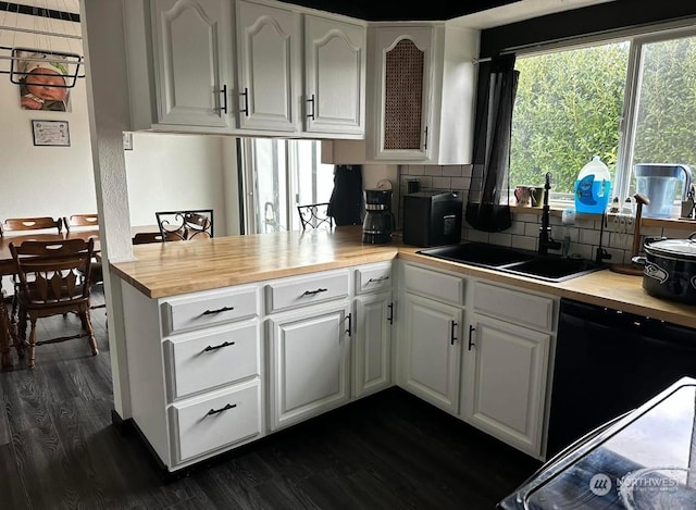 kitchen with black dishwasher, sink, white cabinets, and dark hardwood / wood-style floors