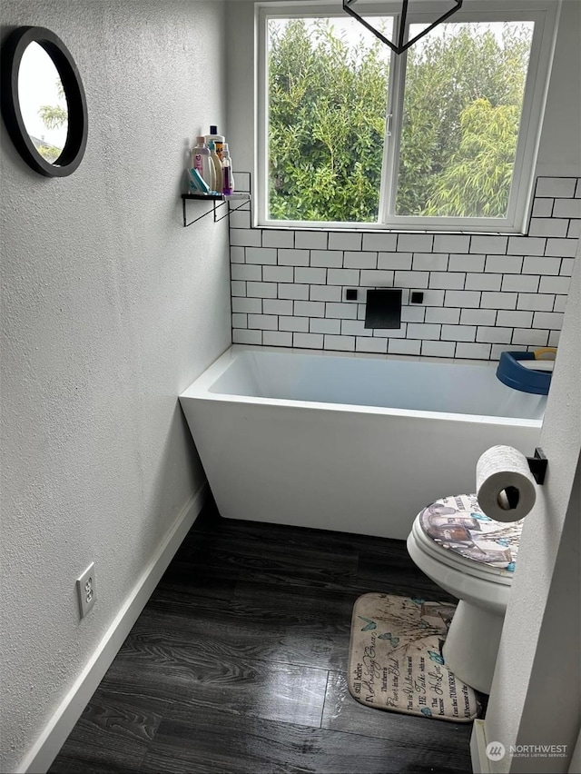 bathroom with a bath and hardwood / wood-style floors