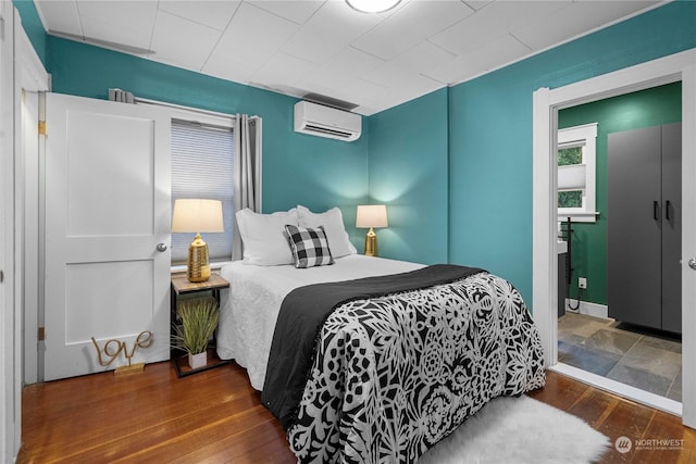 bedroom with hardwood / wood-style floors and a wall mounted AC