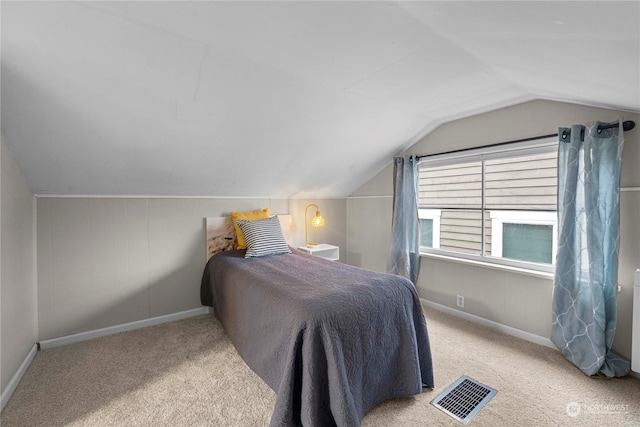 carpeted bedroom featuring visible vents, baseboards, and vaulted ceiling