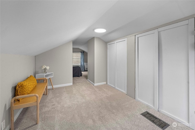 living area featuring baseboards, visible vents, carpet floors, and lofted ceiling