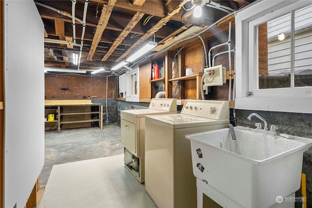 washroom with a sink, a workshop area, laundry area, and washing machine and clothes dryer