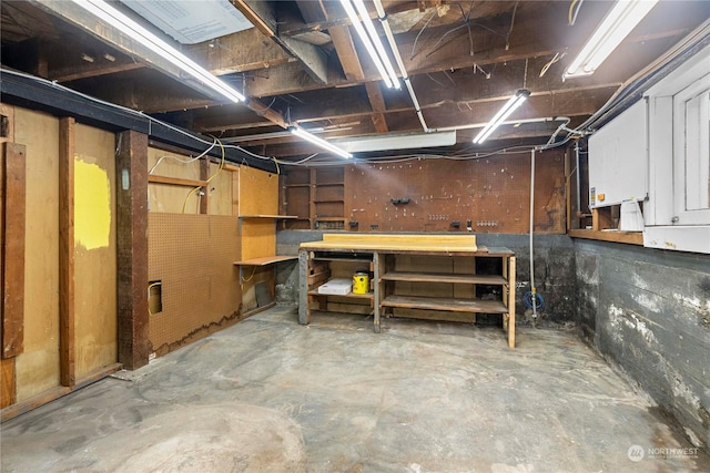 unfinished basement featuring a workshop area