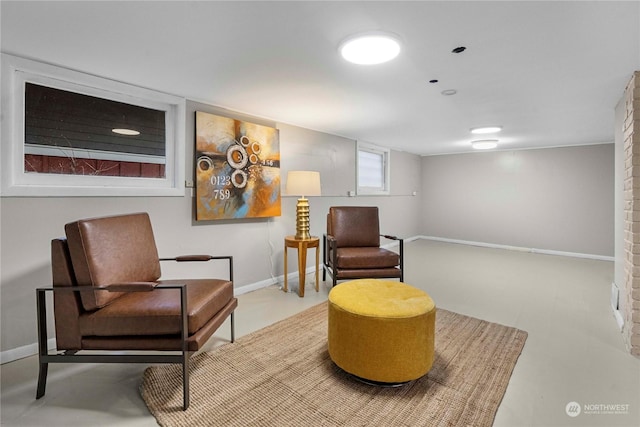 living area featuring finished concrete floors and baseboards