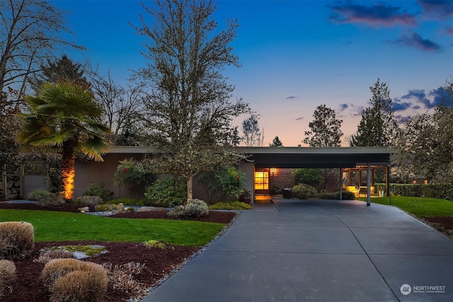 view of front of home featuring a carport and a yard