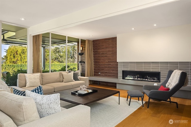 living room featuring a tiled fireplace and hardwood / wood-style floors