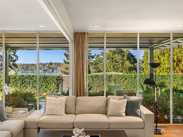 sunroom with a wealth of natural light and a water view