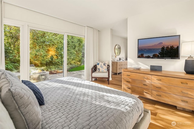 bedroom with access to exterior and light hardwood / wood-style floors