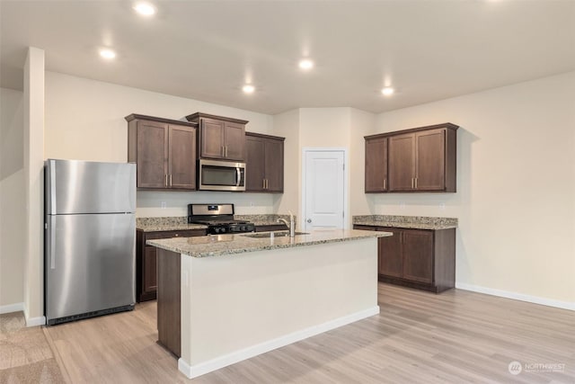 kitchen with stainless steel appliances, light hardwood / wood-style floors, sink, and dark brown cabinets