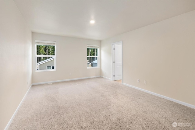 spare room featuring light carpet