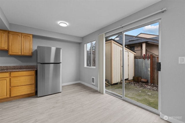 kitchen with stainless steel fridge and light wood-type flooring