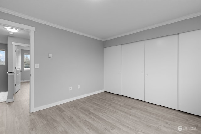 unfurnished bedroom with ornamental molding, a closet, and light wood-type flooring