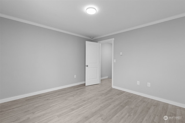 empty room featuring crown molding and light hardwood / wood-style flooring