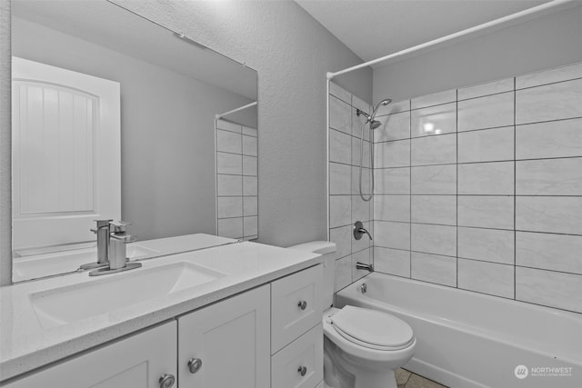 full bathroom with vanity, tiled shower / bath combo, and toilet