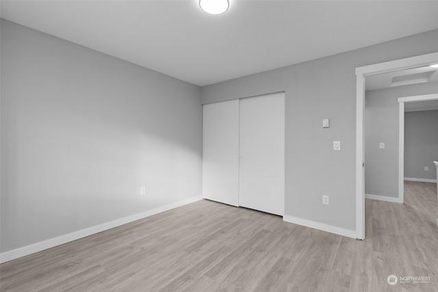 unfurnished bedroom with light hardwood / wood-style flooring and a closet