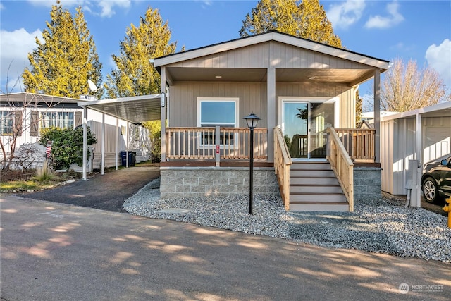 manufactured / mobile home featuring a carport and covered porch