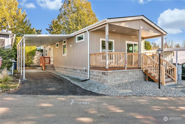 manufactured / mobile home with a carport and a porch