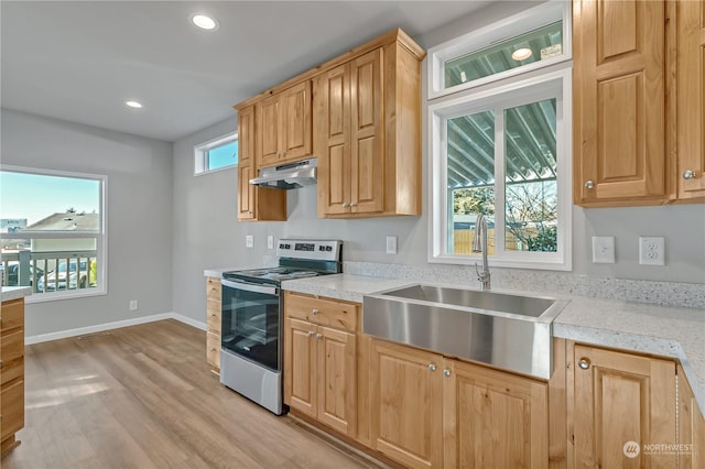 kitchen with light stone countertops, sink, light hardwood / wood-style flooring, and electric stove