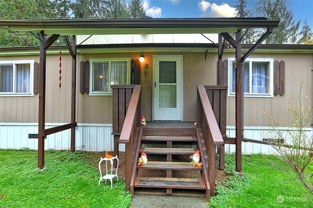 property entrance with a lawn