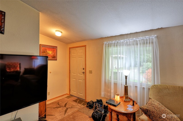 entryway featuring light carpet, vaulted ceiling, and a textured ceiling