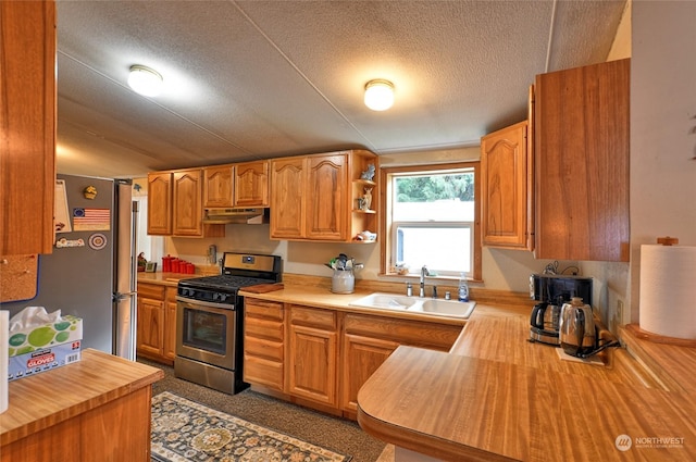 kitchen with stainless steel appliances, butcher block counters, sink, and a textured ceiling