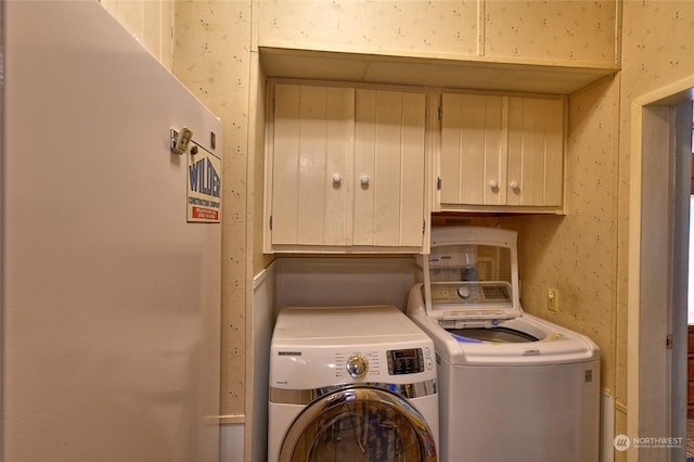 laundry room featuring washer and dryer and cabinets