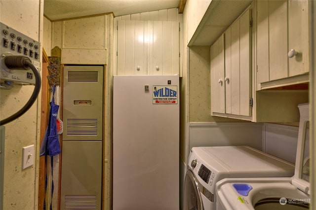 washroom featuring cabinets and washer and dryer