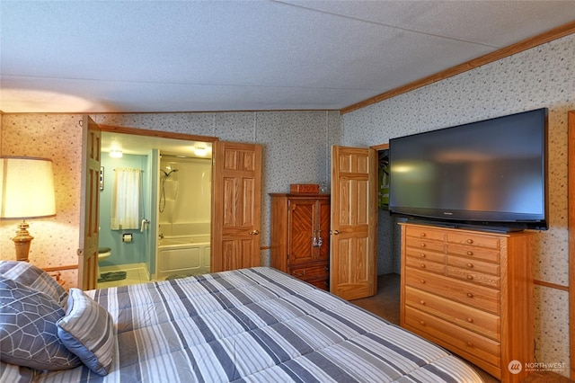 bedroom featuring crown molding, ensuite bathroom, and vaulted ceiling