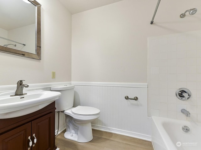 full bathroom with vanity, tiled shower / bath, hardwood / wood-style floors, and toilet