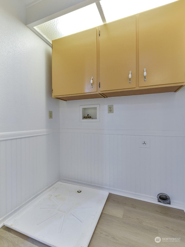 laundry room featuring washer hookup, cabinets, and light wood-type flooring