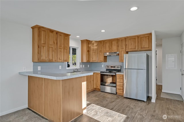 kitchen with sink, light hardwood / wood-style flooring, appliances with stainless steel finishes, tasteful backsplash, and kitchen peninsula