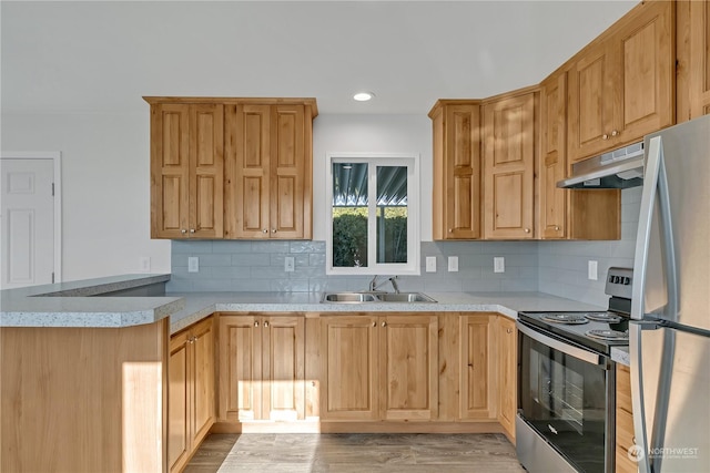 kitchen featuring sink, light hardwood / wood-style flooring, appliances with stainless steel finishes, light brown cabinetry, and decorative backsplash