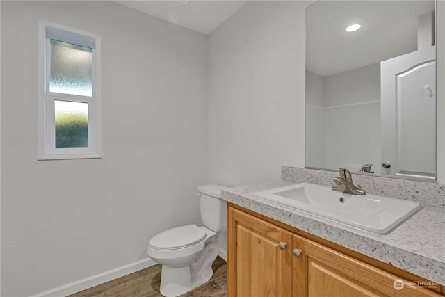 bathroom with vanity, hardwood / wood-style floors, and toilet