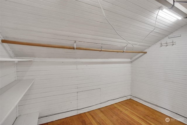 spacious closet with hardwood / wood-style floors and vaulted ceiling