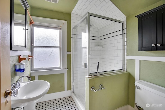 bathroom with an enclosed shower, sink, plenty of natural light, and toilet