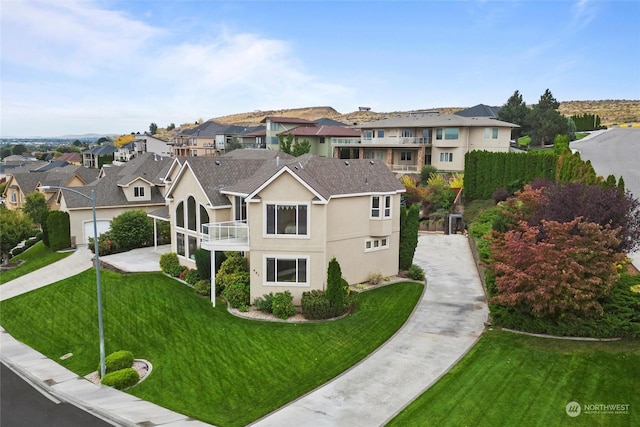 view of front of property featuring a balcony and a front yard