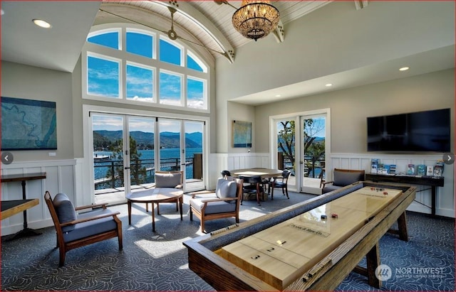 carpeted living room featuring vaulted ceiling, french doors, and a chandelier