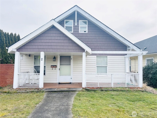 bungalow-style home with covered porch and a front lawn