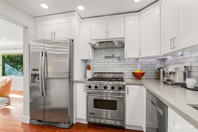 kitchen with stainless steel appliances, white cabinetry, backsplash, and dark hardwood / wood-style flooring