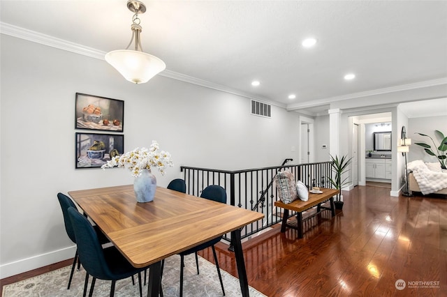 dining space featuring crown molding, dark hardwood / wood-style flooring, and ornate columns