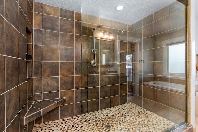 bathroom featuring separate shower and tub and a textured ceiling