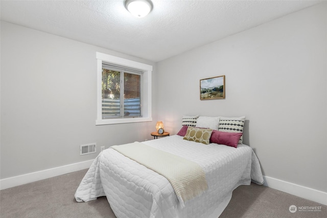 carpeted bedroom with a textured ceiling