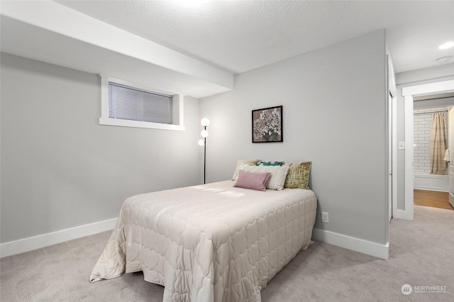 bedroom with light colored carpet and a textured ceiling