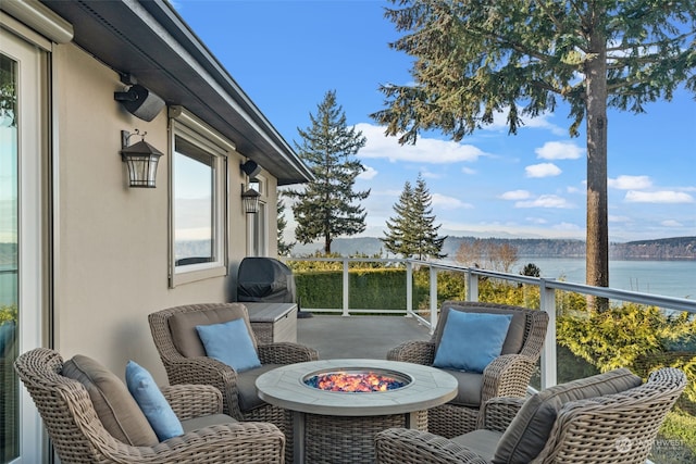 exterior space with a water view and an outdoor fire pit